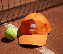 Foto di una palla da tennis e un berretto con visiera di Sisport 